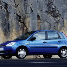 Niebieski Ford Fiesta MK5 zaparkowany przy skalnej ścianie.