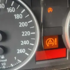 Kontrolka DTC BMW: kontrola trakcji i stabilności aktywna. Pomarańczowy symbol z kółkiem i wykrzyknikiem.