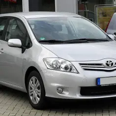Srebrny Toyota Auris 1.6 benzyna zaparkowany na kostce brukowej.