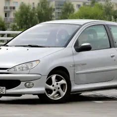 Srebrny Peugeot 206 1.4 benzyna na parkingu.