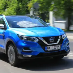 Błękitny Nissan Qashqai 2.0 benzyna w ruchu miejskim.