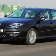 Czarny Renault Laguna 3 2.0 dCi w ruchu drogowym. Elegancki sedan z charakterystycznym przodem i felgami.