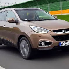 Brązowy Hyundai ix35 na drodze. Wiele pozytywnych hyundai ix35 opinie potwierdza jego wszechstronność.