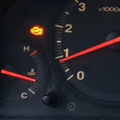 Kontrolka silnika świeci się, sygnalizując potencjalne kody błędów. Obok wskaźnik temperatury i obrotomierz.