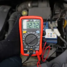 Sprawdzanie akumulatora miernikiem: odczyt 12.72V wskazuje na dobry stan baterii.