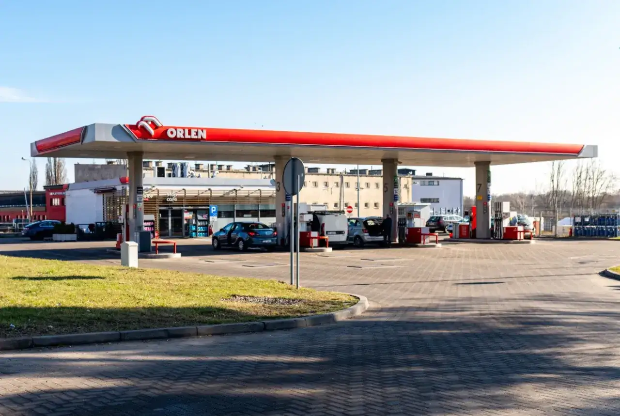 Stacja Orlen z samochodami przy dystrybutorach. Kierowcy tankują, sprawdzając aktualną cenę gazu LPG.