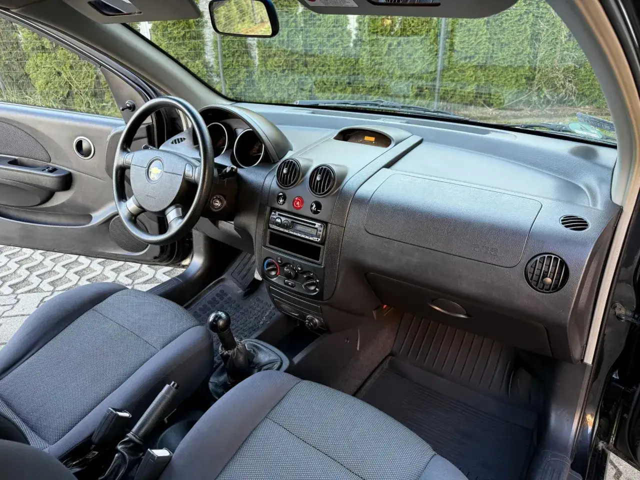Wnętrze chevrolet kalos: kierownica, deska rozdzielcza z radiem, dźwignia zmiany biegów i siedzenia.