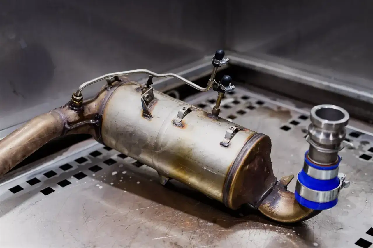 Filtr DPF, kluczowy element systemu egr, leży na metalowej powierzchni, gotowy do montażu.