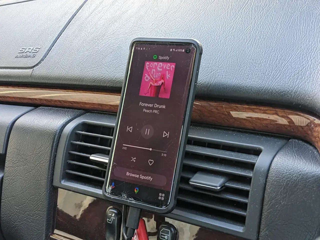 Telefon podłączony do ładowarki w samochodzie, odtwarza muzykę ze Spotify. Prosty sposób, jak połączyć telefon z samochodem dla lepszej podróży.